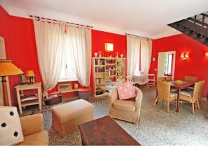 a living room with red walls and a table and chairs at Villa Casa Rosa in Procchio