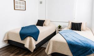 two beds sitting next to each other in a bedroom at Acogedor departamento céntrico vista al lago in Villarrica