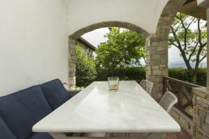 a white table with a glass on top of it at Villa Thea in Kalogria