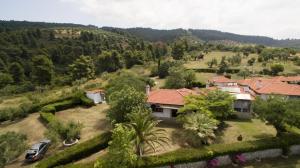 a house on a hill with a car parked in front at Villa Thea in Kalogria