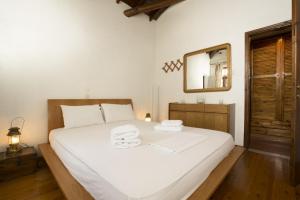 a bedroom with a large white bed with towels on it at Villa Thea in Kalogria
