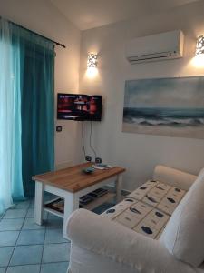 a living room with a table and a couch at Villetta bifamiliare con vista mare "Poggio Tavolara" in Porto San Paolo