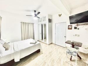 a white bedroom with a bed and a desk at Mi Refugio 1 in Río San Juan