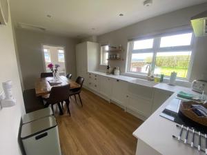 a kitchen with a table and a dining room at 1 Shawsmuir Cottage in Thornhill