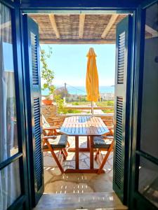 a table and chairs on the balcony of a house at Cyclades Serenity Beach House in Kipri