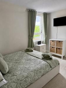 a bedroom with a bed with green curtains and a window at 15 By The Shore in Caol