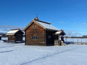 a wooden cabin with snow on the ground at Bonäs bygdegård in Mora