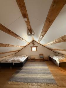a attic room with two beds and a window at Bonäs bygdegård in Mora
