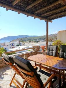 a patio with a wooden table and chairs on a roof at Cyclades Serenity Beach House in Kipri