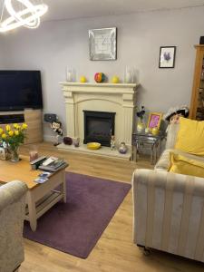 a living room with a couch and a fireplace at Hillside Luxury Bed & Breakfast in Ballycastle +3 photos