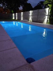 a swimming pool lit up at night with blue lights at Quinta El Encuentro Junín in Junín