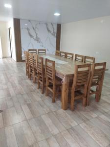 a wooden table with wooden chairs and a table and a table and a table at Quinta El Encuentro Junín in Junín