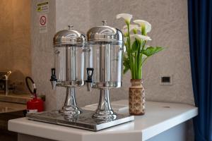 two silver appliances on a counter with flowers in a vase at Hotel Villa Irene & Spa in Rimini +85 photos