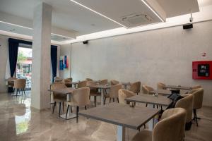 a restaurant with tables and chairs in a room at Hotel Villa Irene & Spa in Rimini
