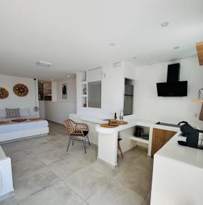 a white kitchen with a table and chairs in a room at Irini's House Sunbeam in Dhragoulás