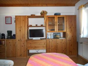 a room with a tv on a wooden cabinet at Familienferienhof Sell´s Scheune in Sundhausen