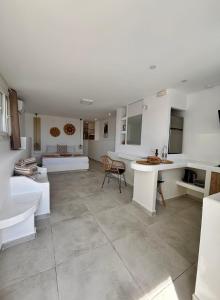 a large white room with a table and a couch at Irini's House Sunbeam in Dhragoulás