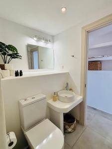 a white bathroom with a toilet and a sink at Irini's House Sunbeam in Dhragoulás +17 photos