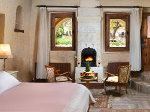 a bedroom with a bed and a fireplace at Minia Cave Hotel in Ortahisar
