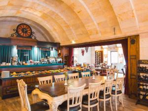 a restaurant with a table and chairs and a clock at Minia Cave Hotel in Ortahisar +28 photos