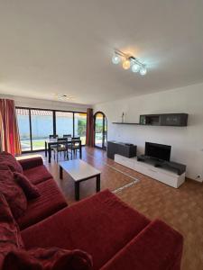 a living room with a red couch and a table at Sun Club Bungalows in Playa del Ingles