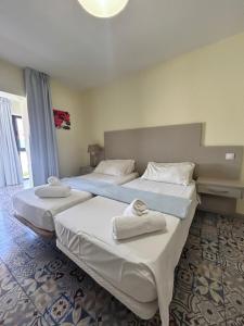 two beds in a hotel room with towels on them at Sun Club Bungalows in Playa del Ingles +39 photos