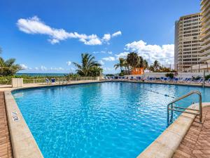 a large pool with blue water in a resort at Beachfront Condo with Pool, Balcony & Ocean Views in Fort Lauderdale