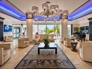 a large living room with a large chandelier at Beachfront Condo with Pool, Balcony & Ocean Views in Fort Lauderdale