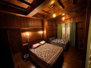 a bedroom with two beds in a wooden room at Udadola Ecolodge in Deniyaya
