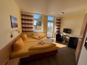 a bedroom with two beds and a living room at Hotel Gesellschaftshaus in Bergen auf Rügen