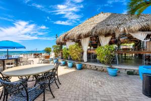 a restaurant on the beach with tables and chairs at Beachfront Condo with Pool, Balcony & Ocean Views in Fort Lauderdale