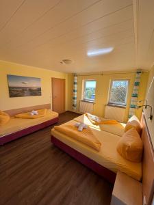 two beds in a room with two windows at Hotel Gesellschaftshaus in Bergen auf Rügen