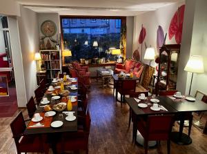 a room with tables and chairs and a living room at Arnaud Bernard Hôtel in Toulouse