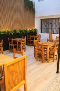 a restaurant with wooden tables and wooden chairs at Absolute Nova Hotel in Medellín