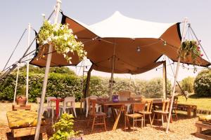a table and chairs under a large umbrella at Aparra Surfcamp Auberge Capbreton in Capbreton +14 photos