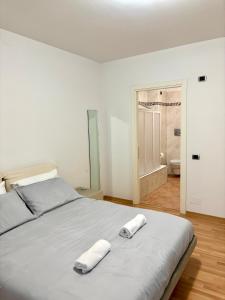 a bedroom with a bed with two towels on it at G&G Suites in Bugia