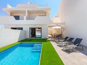 a house with a swimming pool and some chairs at Villa Del Pescador in Santiago de la Ribera