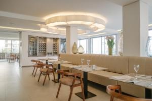 a restaurant with tables and chairs and a large chandelier at Kyrat Amarac - Adults Only in Cala Millor