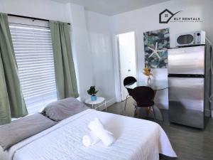 a bedroom with a white bed and a refrigerator at Cozy studio in Hollywood 101 - 1 in Hollywood +22 photos