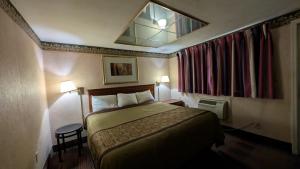 a hotel room with a bed and a mirror at Red Lion Motel Southampton in Southampton