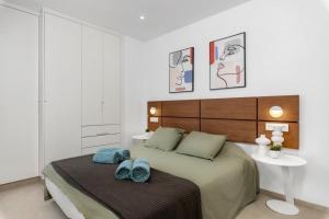 a bedroom with a bed with two blue towels on it at Elegance Apartment "Seaside Retreat" in San Pedro del Pinatar