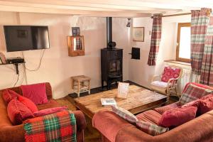 a living room with two couches and a wood stove at La Ferme Des Astres in Les Angles