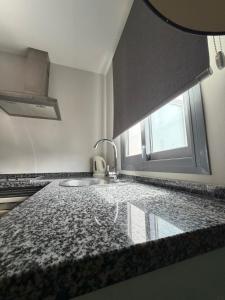 a kitchen counter with a sink and a window at Hotel Avenida 31 in Marbella +74 photos