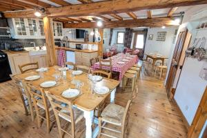 a dining room with wooden tables and chairs at La Ferme Des Astres in Les Angles