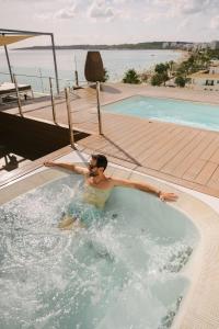 a man in a jacuzzi in a swimming pool at Kyrat Amarac - Adults Only in Cala Millor