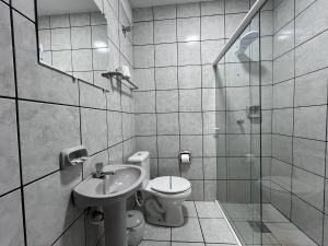 a bathroom with a toilet and a sink and a shower at Rosa's Hotel in Toledo
