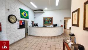 a restaurant with a counter and a clock on the wall at Hotel Bruggemann in Florianópolis