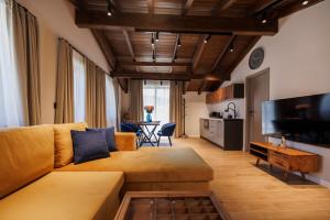 a living room with a couch and a table at Къща за гости Domus Harmonia - Jacuzzi & BBQ near Bansko in Banya