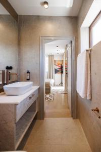 a bathroom with a large white sink and a tub at Къща за гости Domus Harmonia - Jacuzzi & BBQ near Bansko in Banya +34 photos