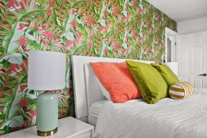 a bedroom with a bed with colorful pillows and a wallpaper at Casa Azul - Waterfront Villa with Pool & Dock in Marco Island